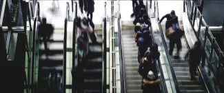 people running up and down escalators
