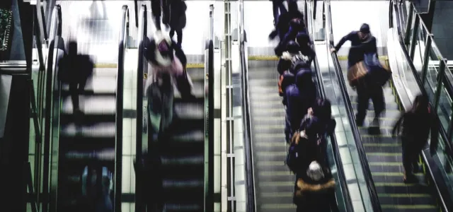 people running up and down escalators
